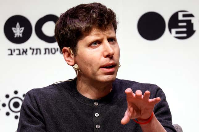 Sam Altman speaking at a conference lifting his hand